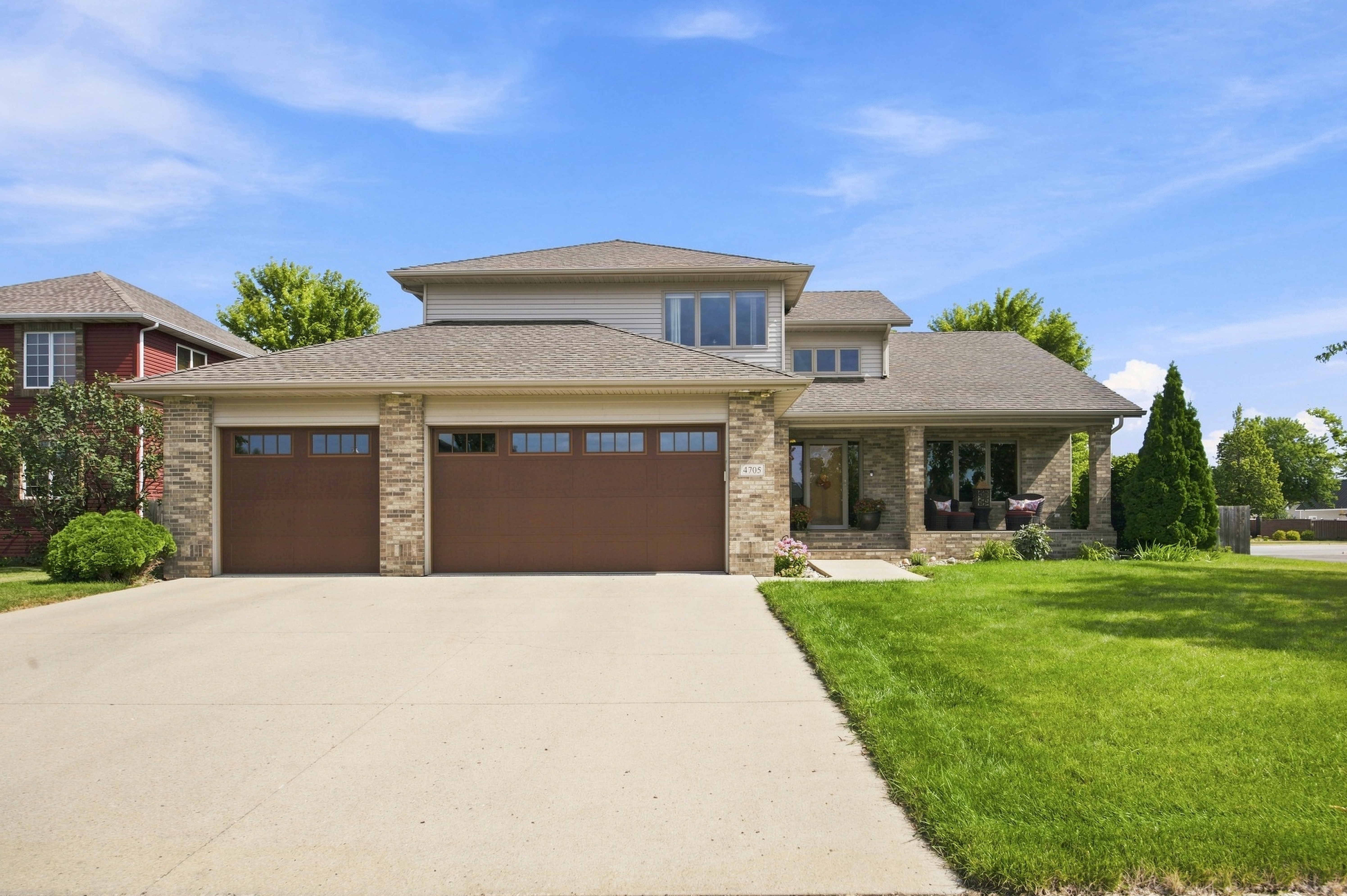 Daytime exterior photo of a home with a clean driveway and manicured lawn